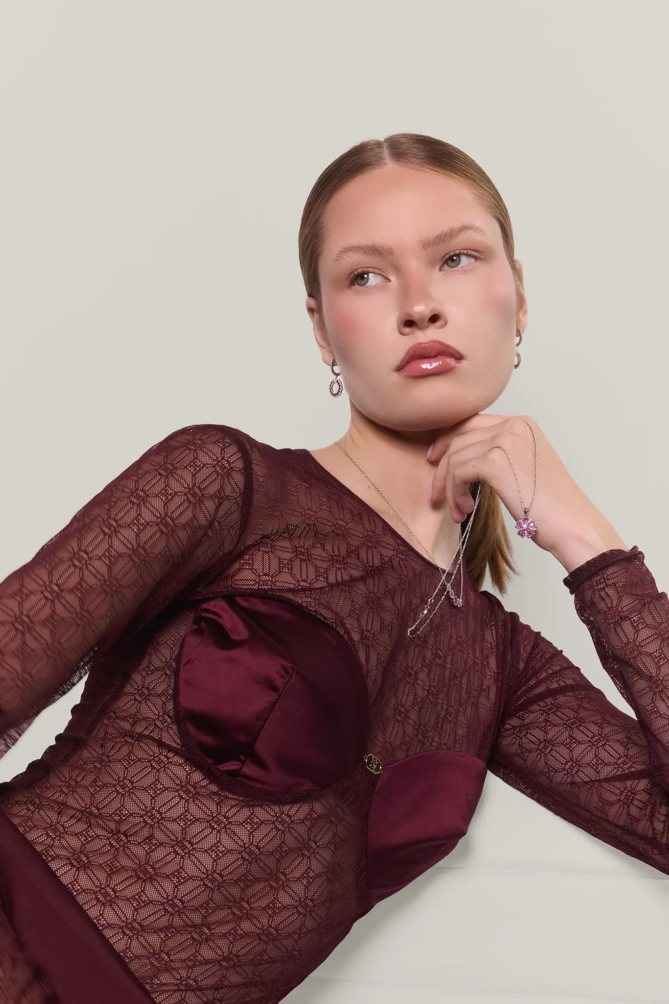 Woman wearing a burgundy top and a pink rose pendant