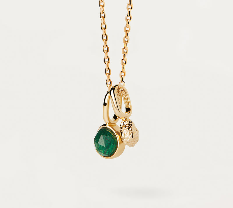 A gold necklace with an emerald drop pendant suspended from a gold chain against a white background.