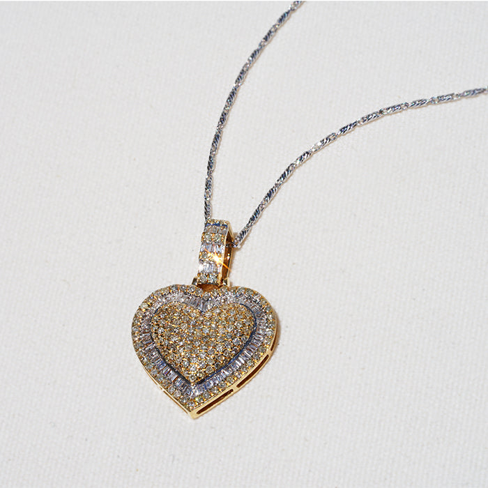 A gold diamond heart necklace featuring delicate pave-set gemstones against a white backdrop.