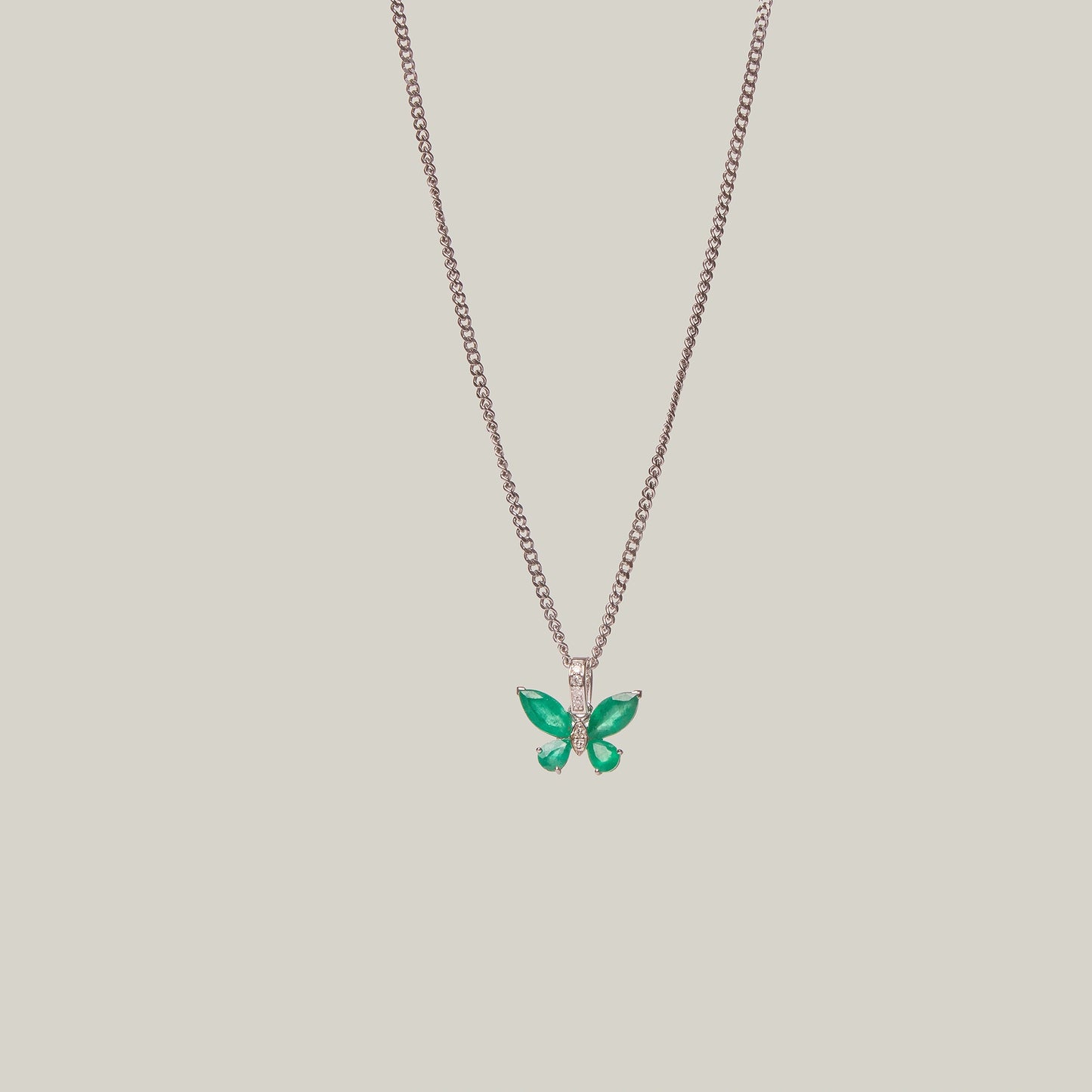 Necklace with a green butterfly pendant on a light gray background