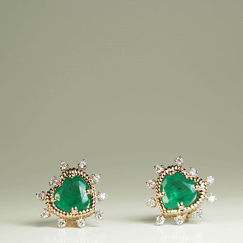 A pair of emerald heart-shaped earrings with diamond accents, crafted in 14K yellow gold.