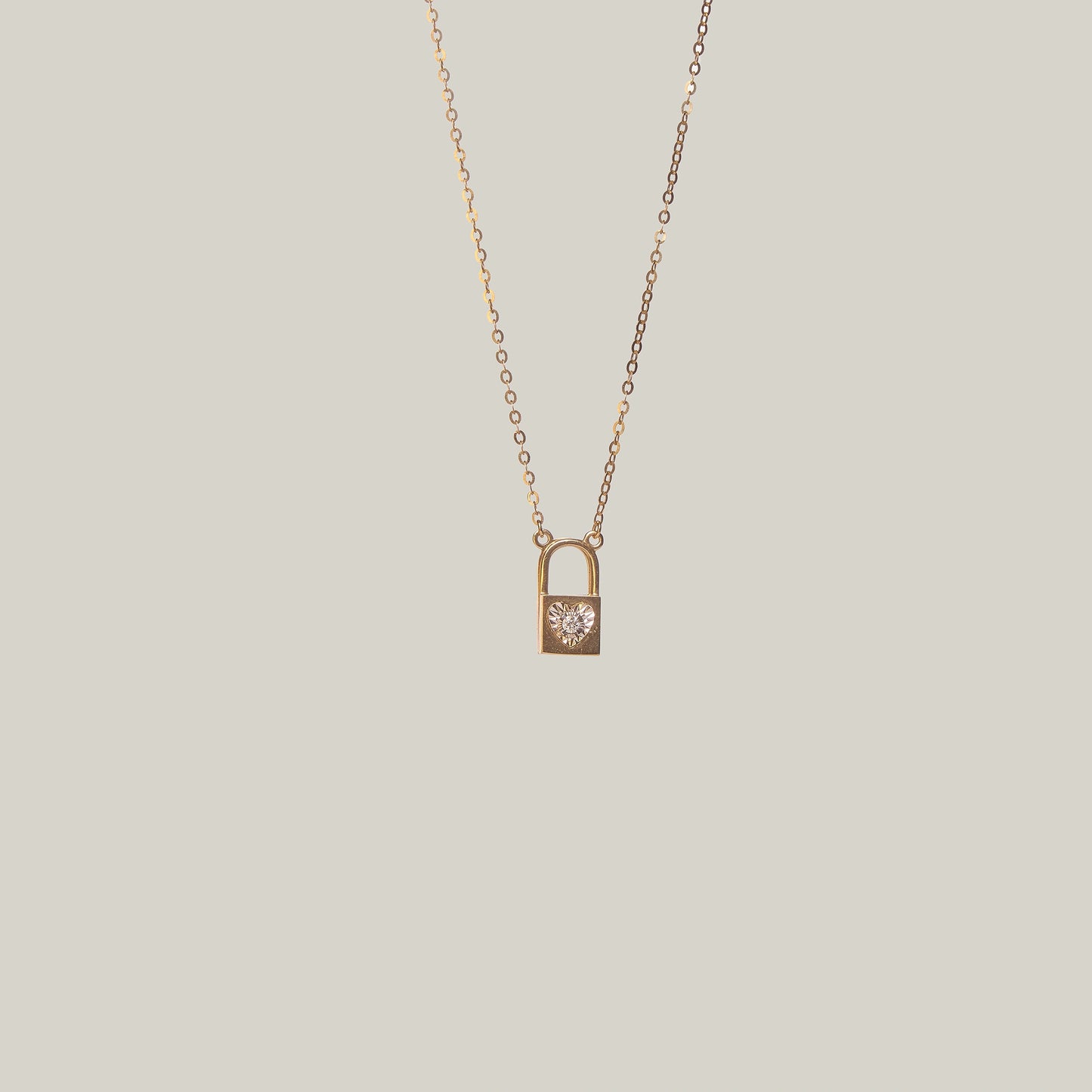 Close-up front-facing view of a gold and diamond padlock necklace on a light gray background