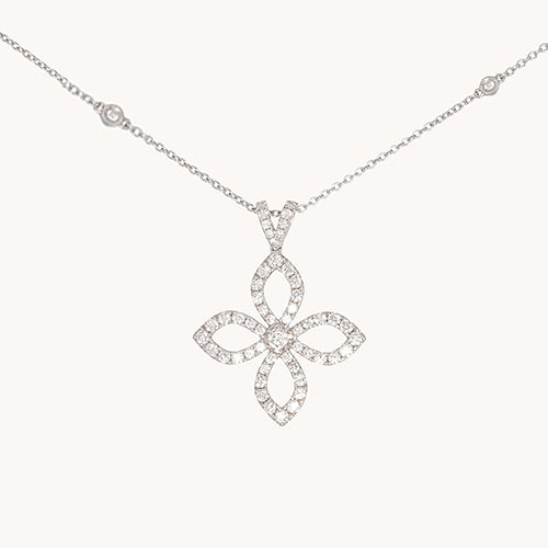 Close up view of a white gold diamond clover pendant suspended from a chain against a white background.