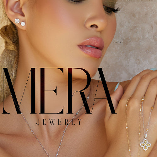 Model wears two diamond earrings, a silver necklace chain and holds a diamond clover pendant.